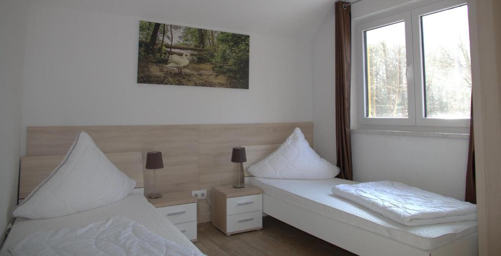 柏林Ferienpark Rübezahl am Müggelsee, Haus 21 Efeu mit eigener Sauna, idealer Ort für Natur- und Erholungssuchende, für Radfahrer, Familien mit Kindern und Hundeliebhaber的一间卧室设有两张白色的床和窗户