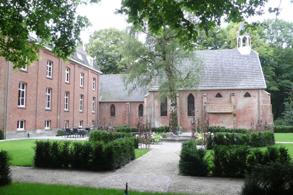 GoirleKlooster Nieuwkerk Goirle的一座大型砖砌建筑,前面有一个庭院