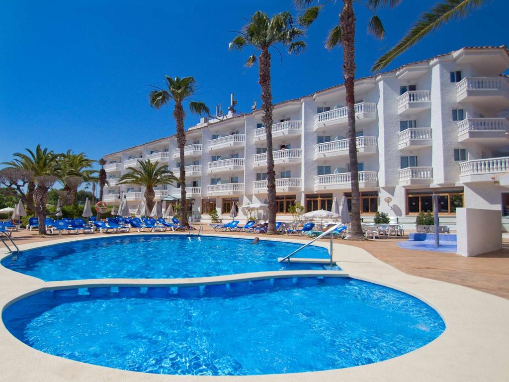 阿尔考斯布里瑟维集团罗马纳酒店的一个带大型游泳池和棕榈树的度假村