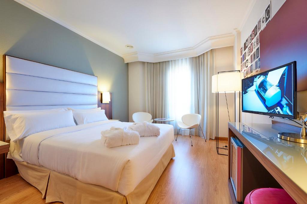 维戈Hotel Vigo Los Galeones Affiliated by Meliá的配有一张床和一台平面电视的酒店客房