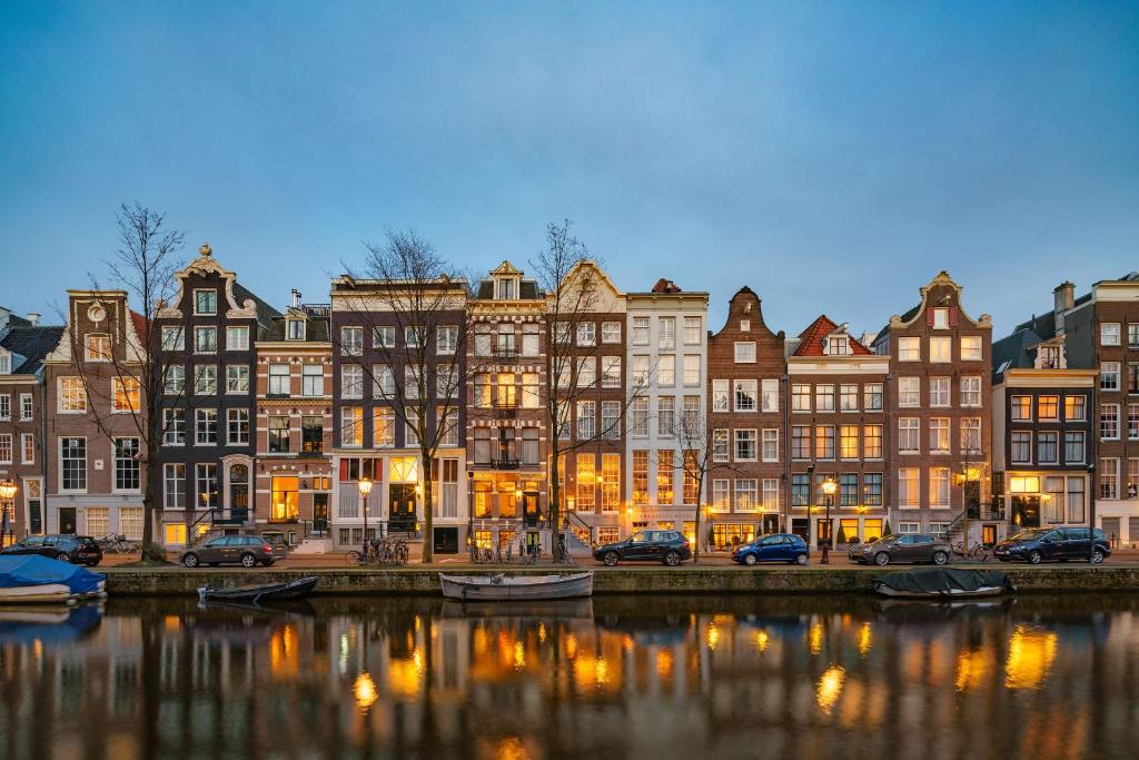 阿姆斯特丹大使酒店的河岸边的一群建筑物,有船