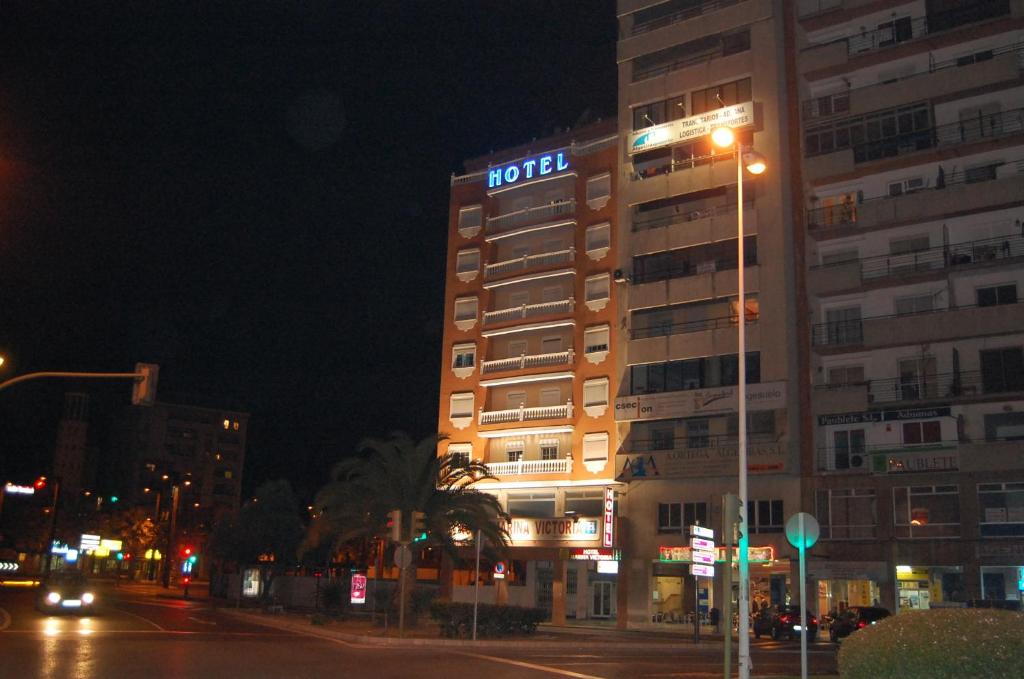 阿尔赫西拉斯维多利亚码头酒店的一座在晚上标有酒店标志的建筑
