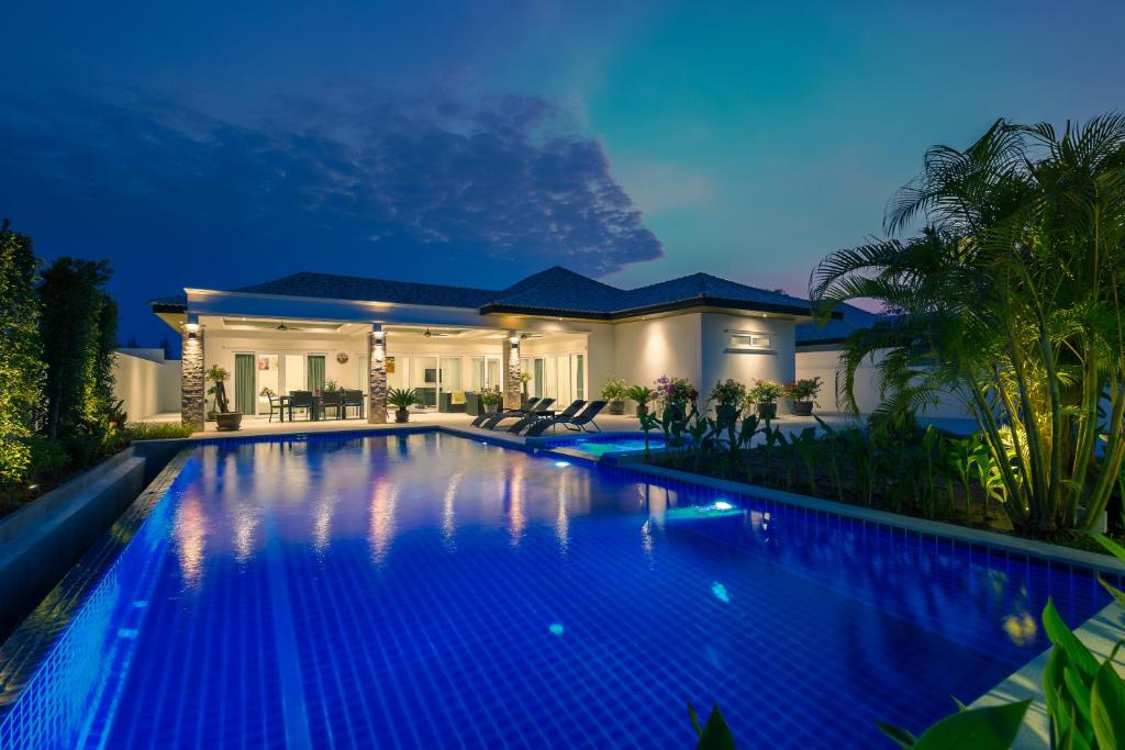 华欣兰花天堂别墅的夜间在房子前面的游泳池