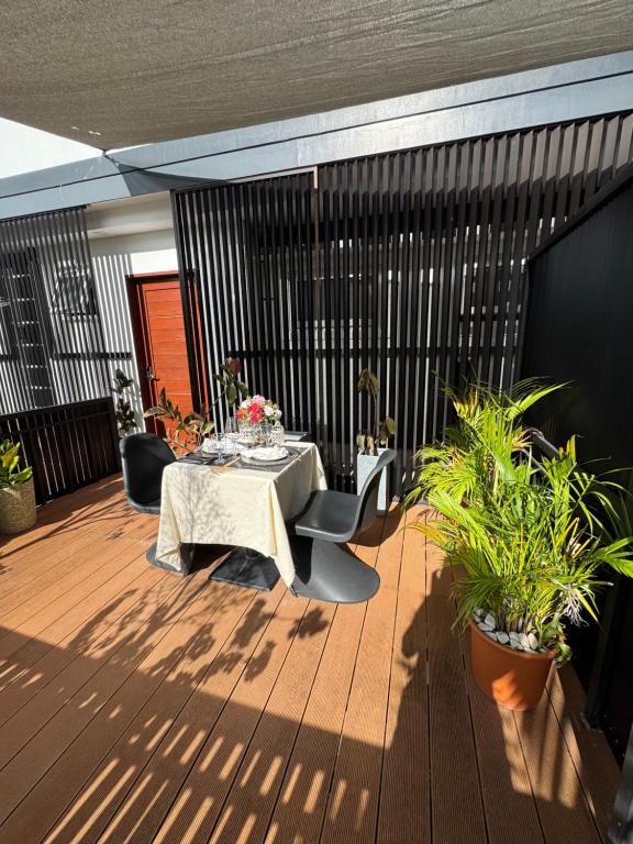 道伊斯Epic Suites Bohol ADULTS ONLY的木制甲板上配有桌椅的天井