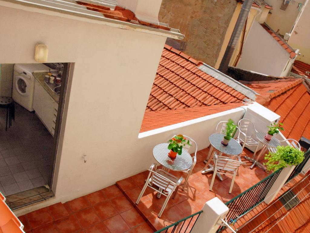 里斯本迎宾旅馆的享有带桌椅的阳台的顶部景色。