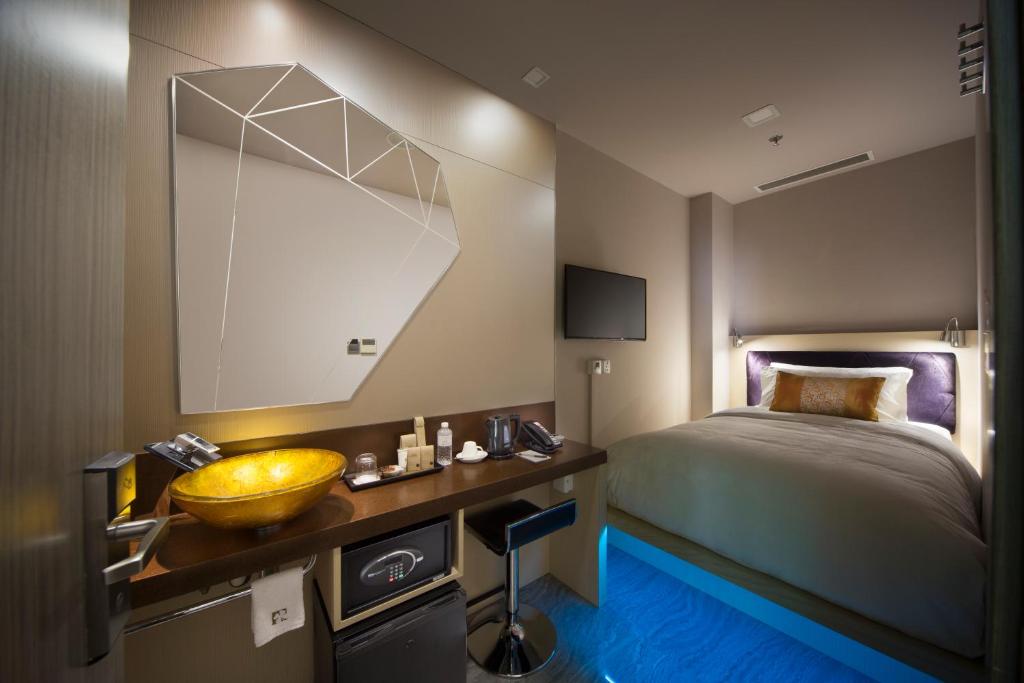 新加坡Hotel Clover 7的一间卧室配有床、水槽和镜子