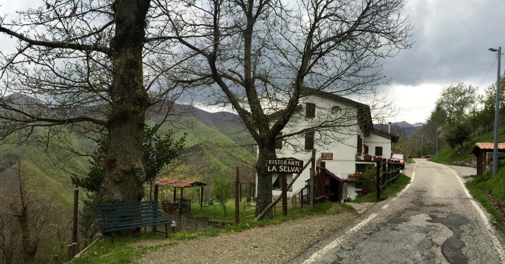 OrsignaAlbergo Ristorante La Selva的房屋旁道路边的标志