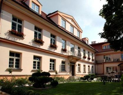 布拉格布拉格城堡酒店的一座带窗户和植物的大建筑,位于庭院内