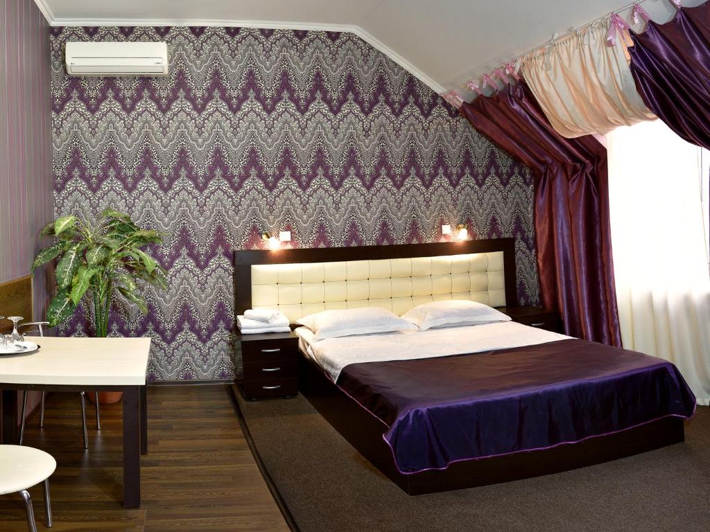 顿河畔罗斯托夫Rostov Hotel的一间卧室设有一张大床和紫色的墙壁