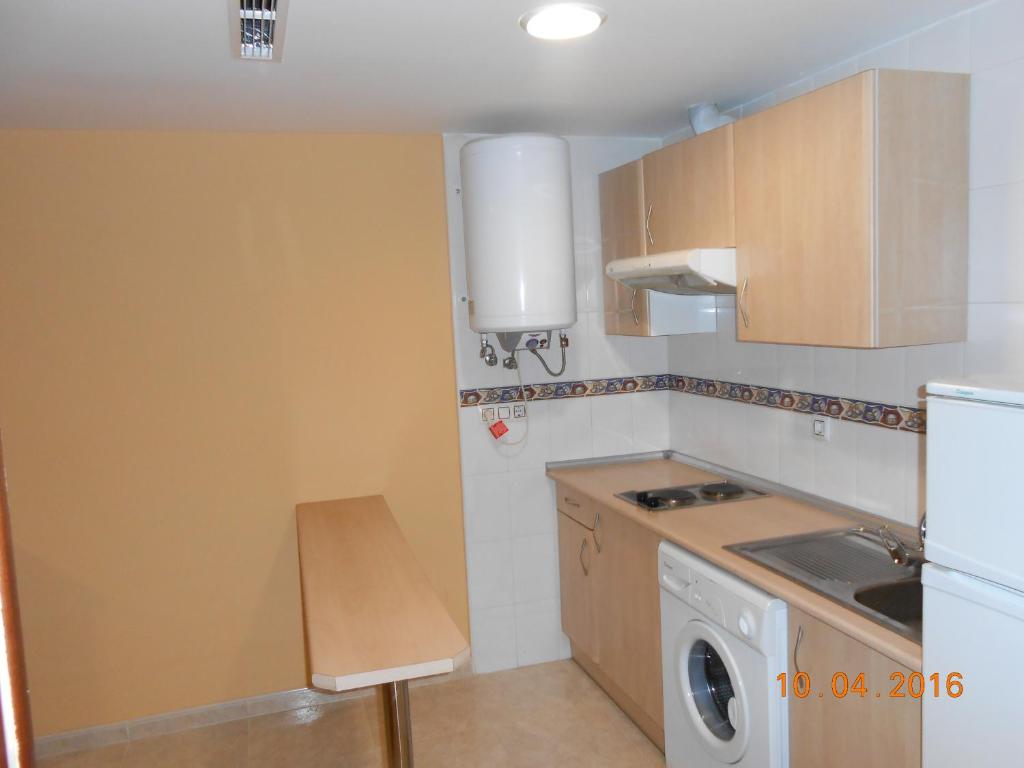 奥卡尼亚赫尔马诺斯公寓酒店的一个带水槽和一台洗衣机的小厨房