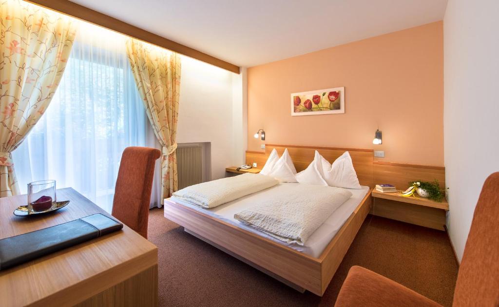 拉古多Pension Morenfeld的酒店客房配有一张床铺和一张桌子。