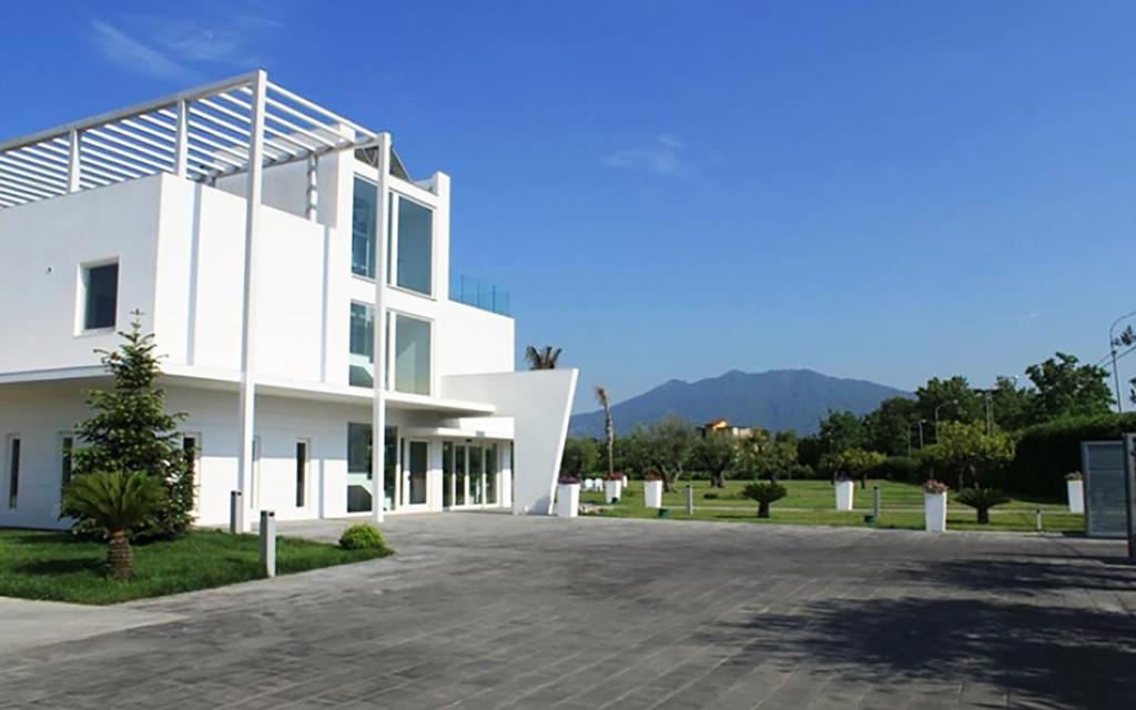 波米利亚诺达尔科Pietrabianca Exclusive Resort的前面有车道的白色建筑