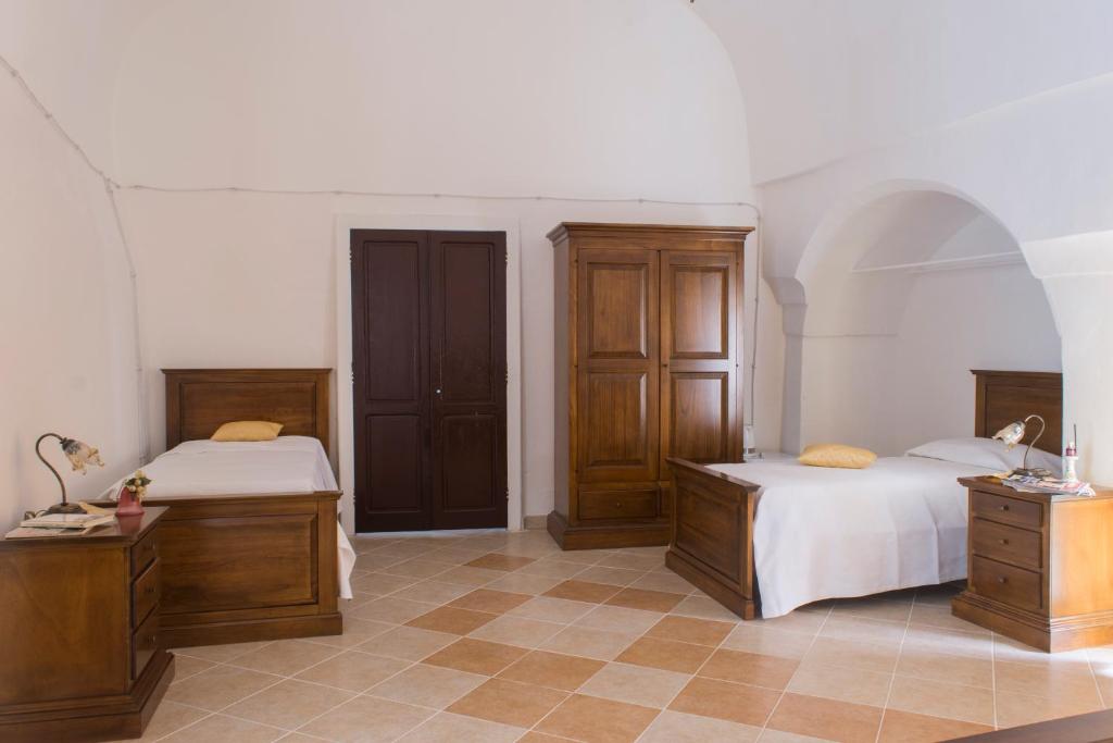 乌真托100 Craste的一间卧室设有两张床和木制橱柜。