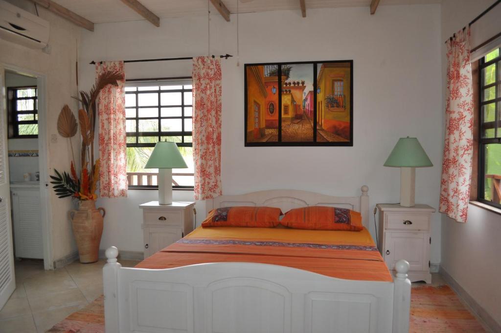 基督教堂市Yellow Bird Apartment的卧室配有带橙色枕头的白色床