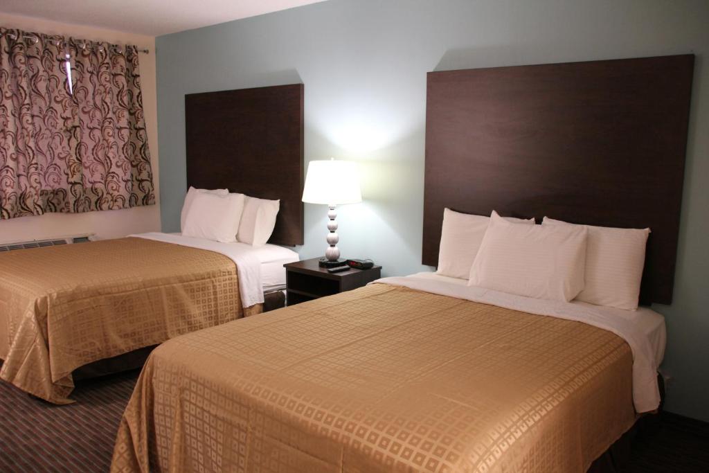 尼亚加拉瀑布Sterling Inn near IAG Airport的酒店客房,设有两张床和一盏灯