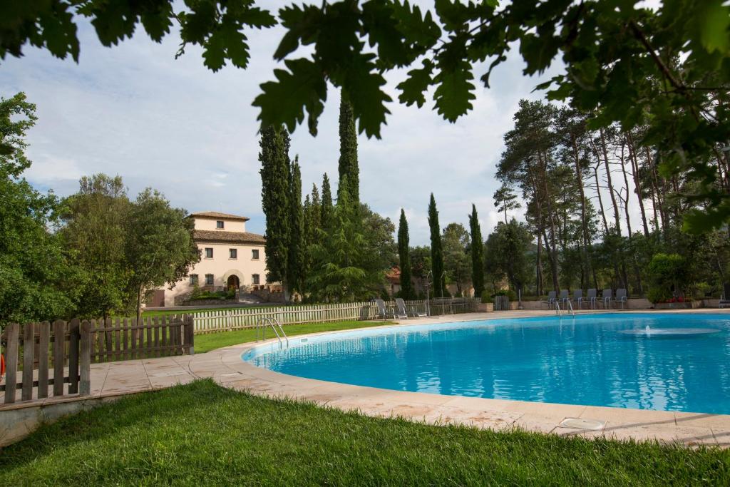 Santa Eulalia de Ríuprimer拉特瑞德尔维拉尔酒店的庭院内的游泳池,后面有房子