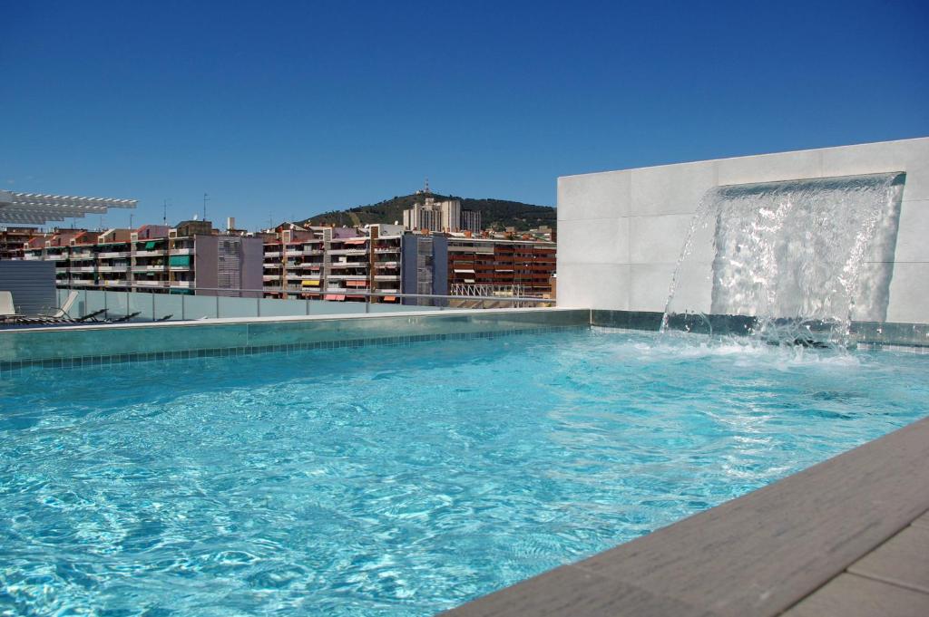巴塞罗那08028公寓的一座建筑顶部的游泳池,上面有一个喷泉