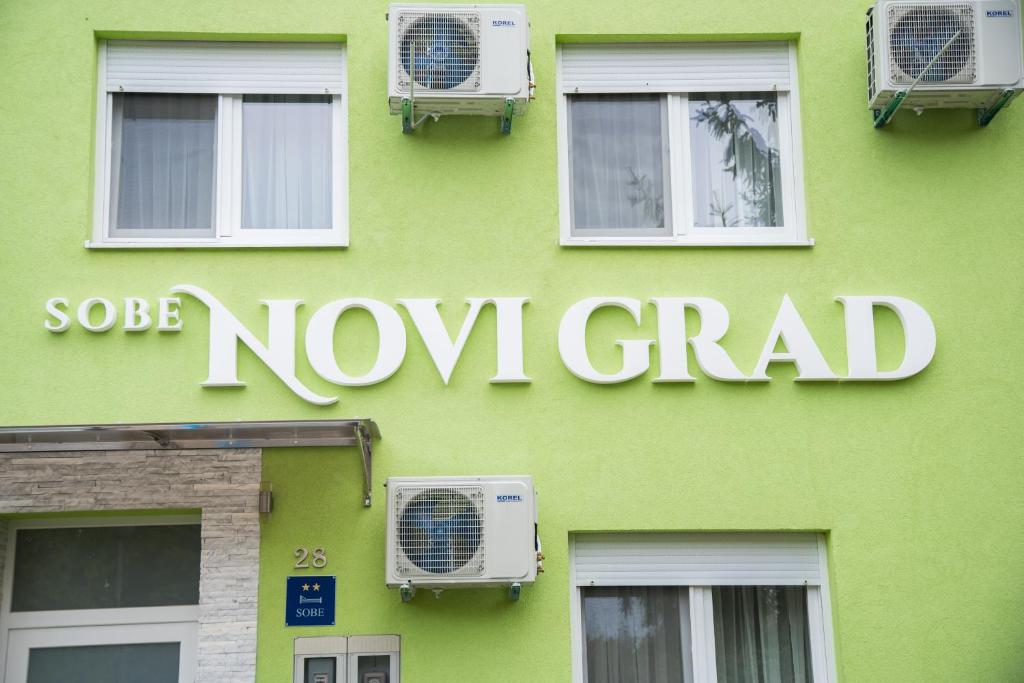 奥西耶克Sobe Novi grad的绿色建筑,上面有新的格勒标志