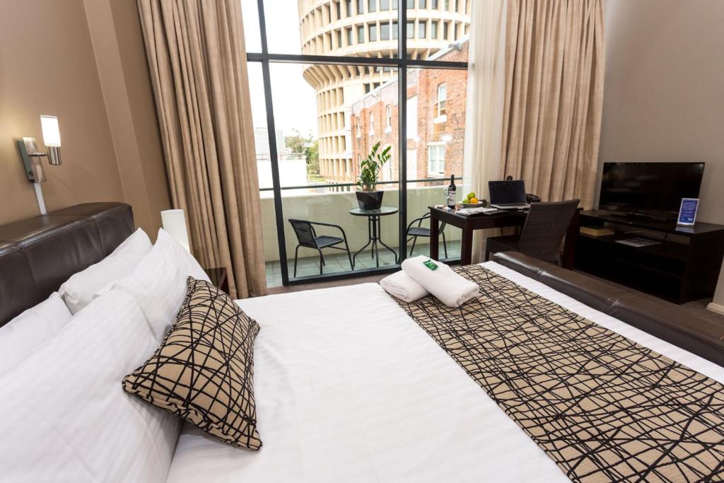 纽卡斯尔Clarendon Hotel的酒店客房设有一张床和一个大窗户
