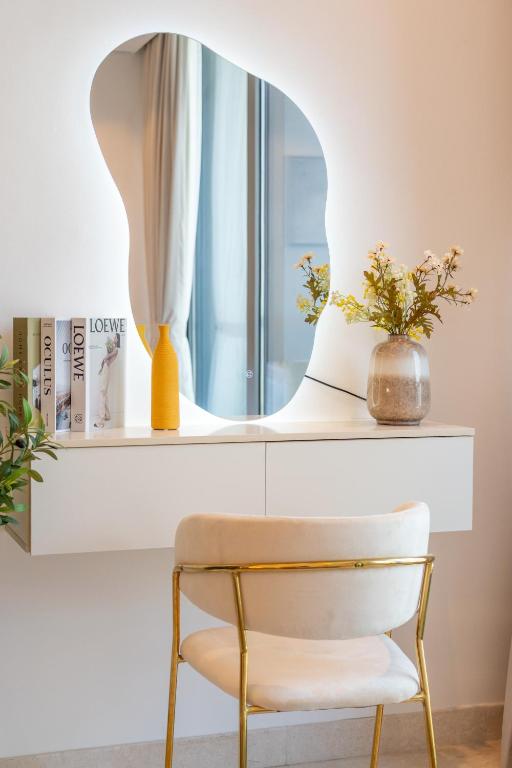 迪拜Chalet Homes - LUX New Studio With 2 Double Beds in Downtown Dubai的白色书桌上方的镜子和椅子