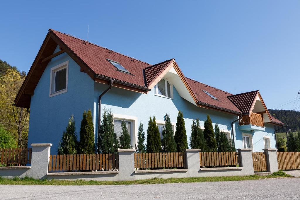 BlatnicaApartmánový Dom River的蓝色的房子,有栅栏和树木