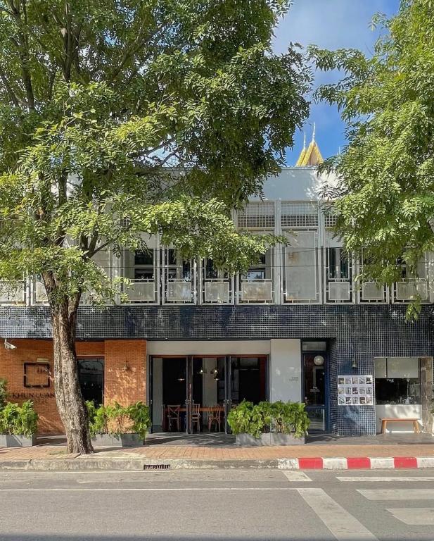 清迈Khunluang Hostel的街道边的一座有树的建筑