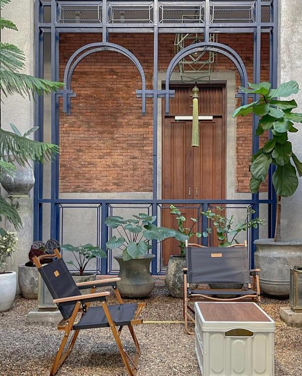 清迈Khunluang Hostel的两把椅子,在一座带门的建筑前