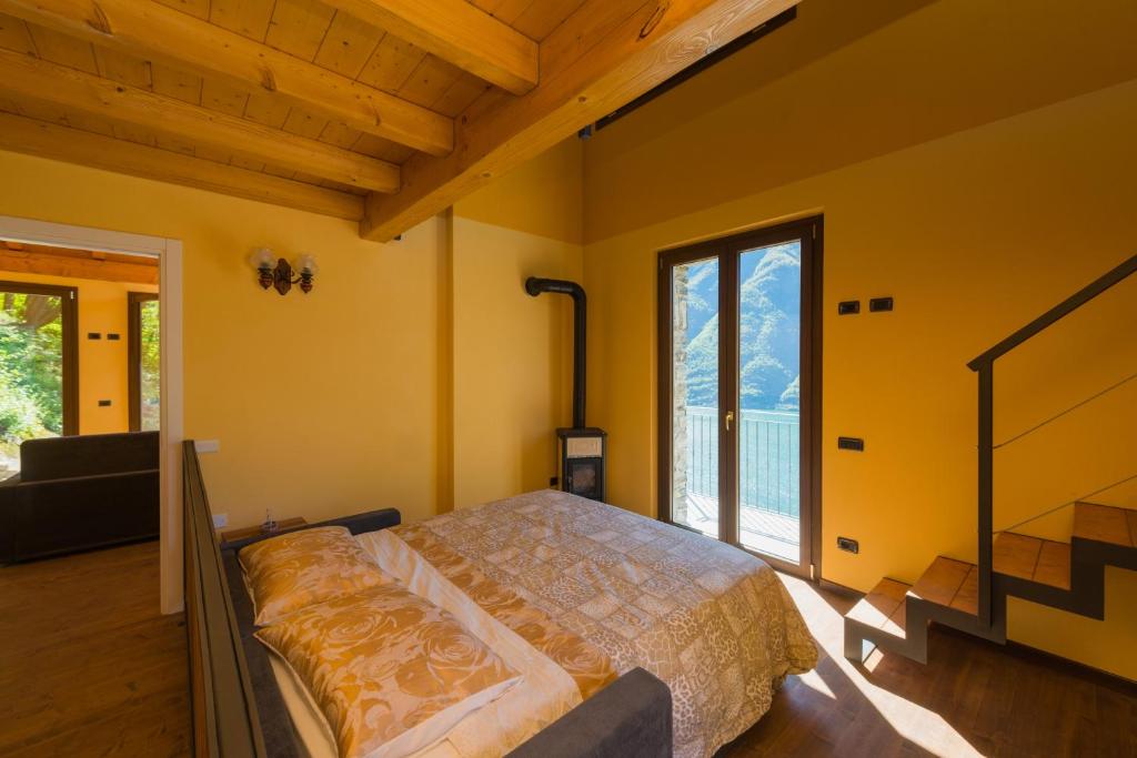 内索Tra Lago e Montagna Baita la Morena的一间卧室设有一张床和一个大窗户
