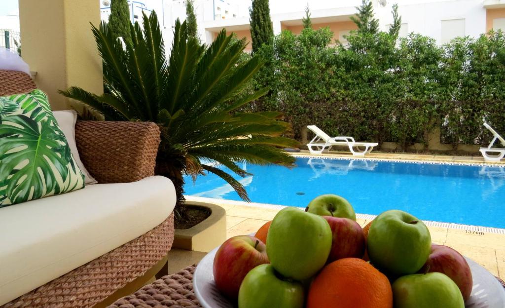 波尔蒂芒Villa Moments - Guest House的游泳池畔的桌子上放上一碗水果