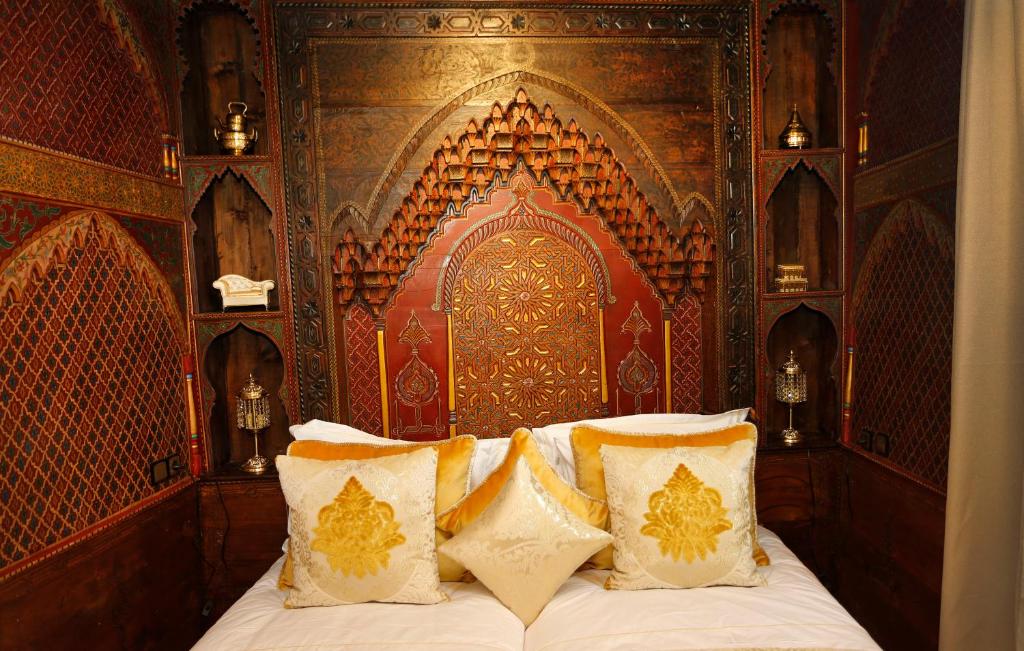 舍夫沙万里亚德彻利法旅馆的一间卧室配有一张带木制床头板的床