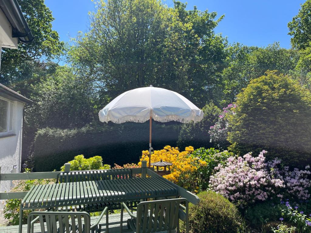 温德米尔The Shades - Bliss In The Heart of Windermere的花园里的带遮阳伞的野餐桌