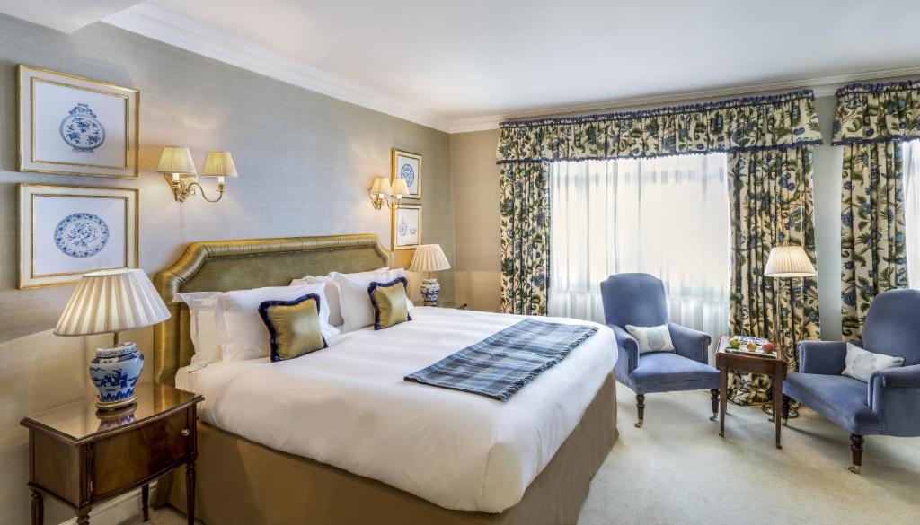 伦敦伦敦斯塔福德酒店的酒店客房带一张大床和两张椅子