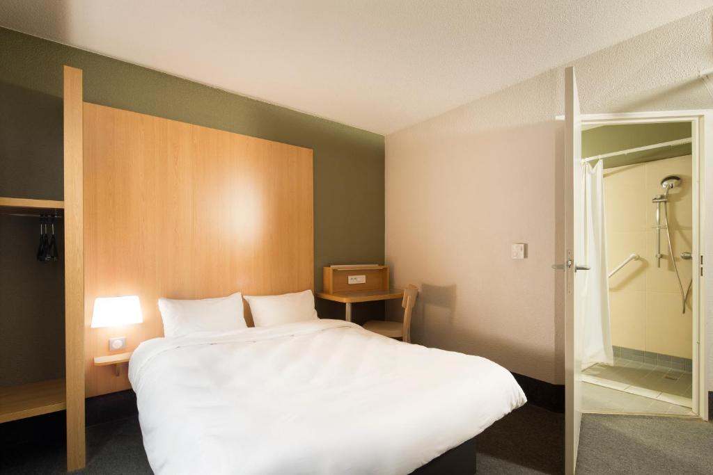 马赛B&B HOTEL Marseille Les Ports的卧室配有一张白色大床和淋浴