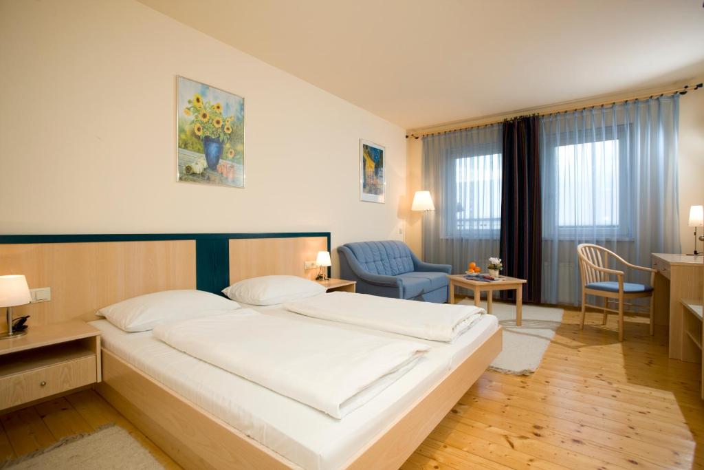 RudersdorfLandgasthof Zum Alten Weinstock的卧室配有一张白色大床和一张蓝色椅子