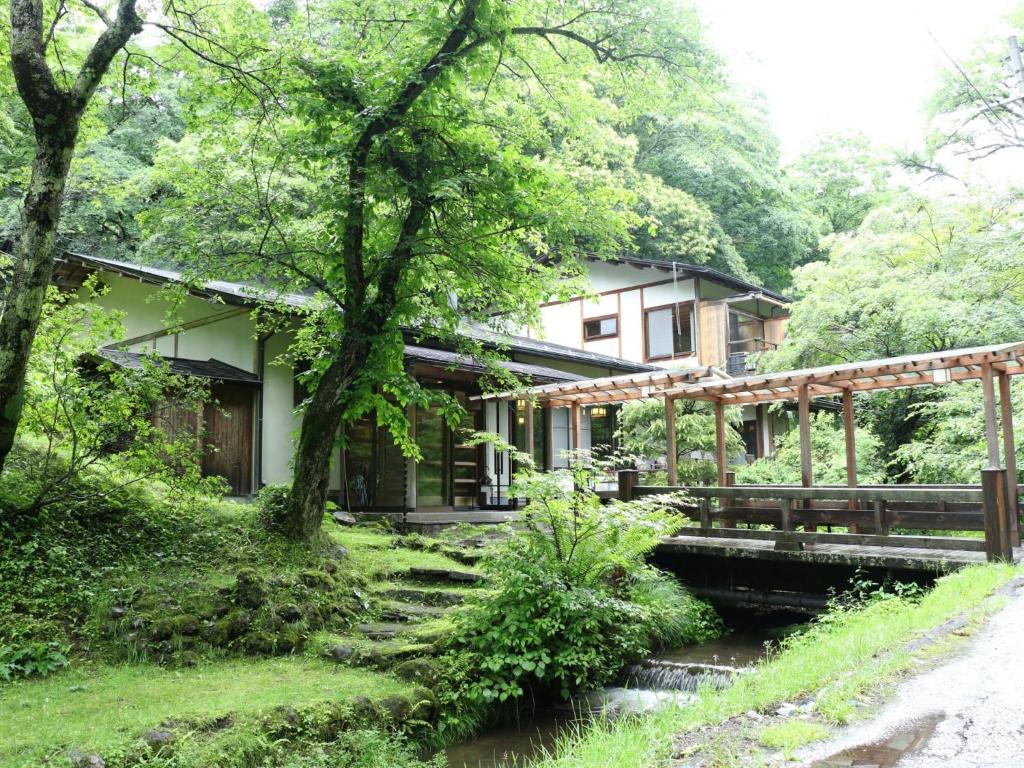 轻井泽小濑温泉酒店的河边一座带桥的房子