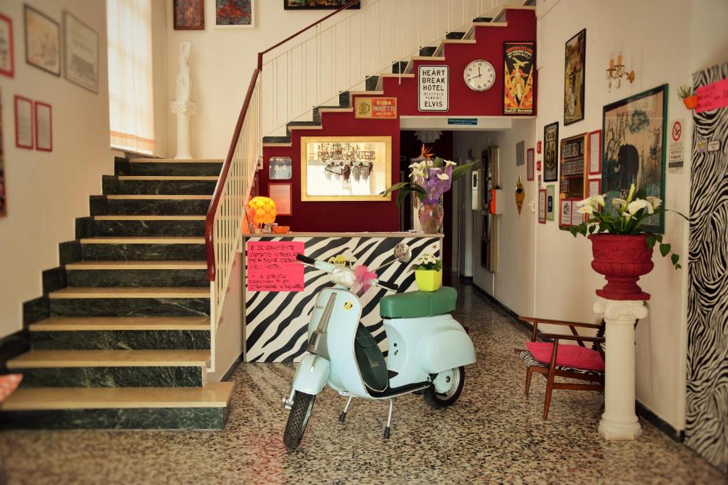 里米尼埃利亚别墅酒店 的停在楼梯旁的走廊上的摩托车