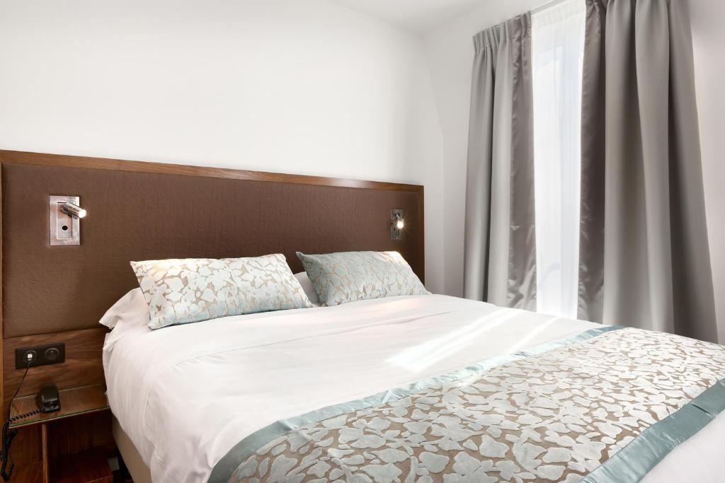 巴黎特伦特酒店的一间卧室设有一张大床和一个窗户。