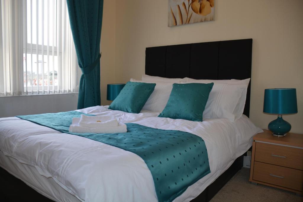 佩斯利Townhead Apartments Gallery View的一间卧室配有一张带蓝色枕头的大床