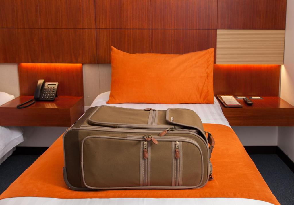 基多芬兰酒店的放在酒店房间床上的手提箱