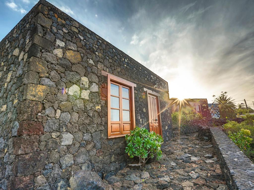 弗龙特拉Estudio Rural de Piedra的一面有窗户的石头房子