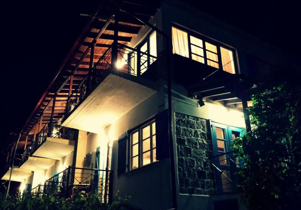 塞尔马Aigaion Guesthouse的一座灯光明亮的建筑,晚上有楼梯