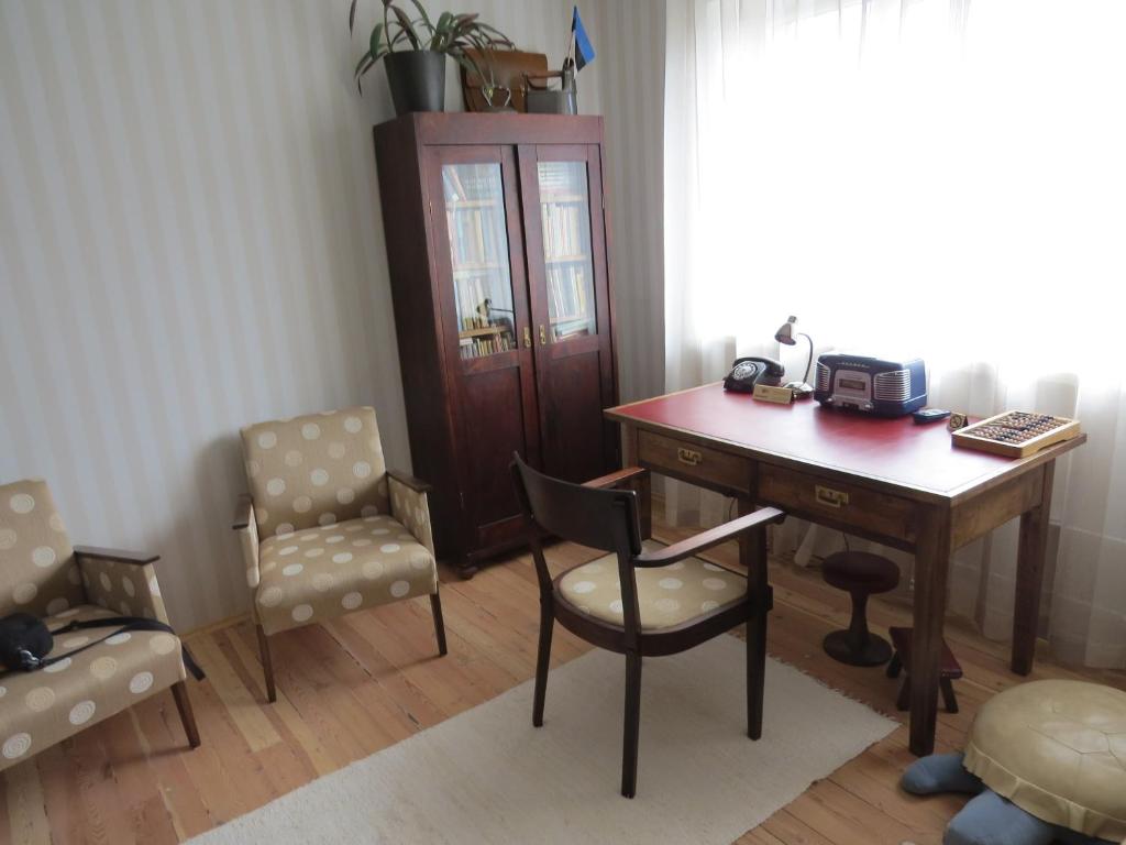 派尔努家庭度假公寓的办公室配有木制书桌、椅子和桌子