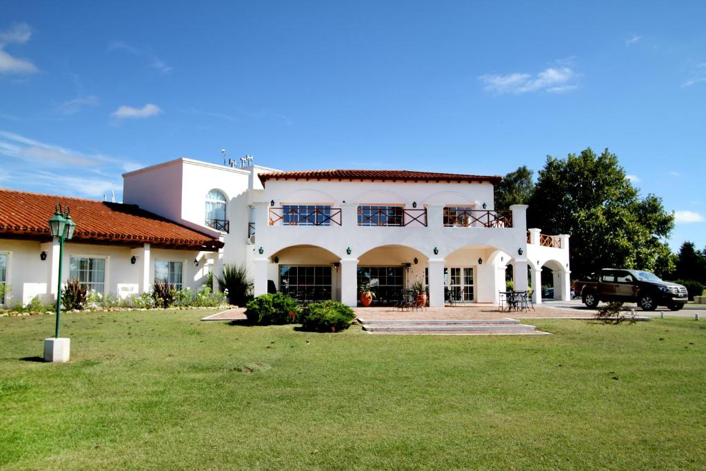 圣罗莎拉凯姆皮纳俱乐部酒店& Spa的一座大型的白色房子,在院子里有停车位