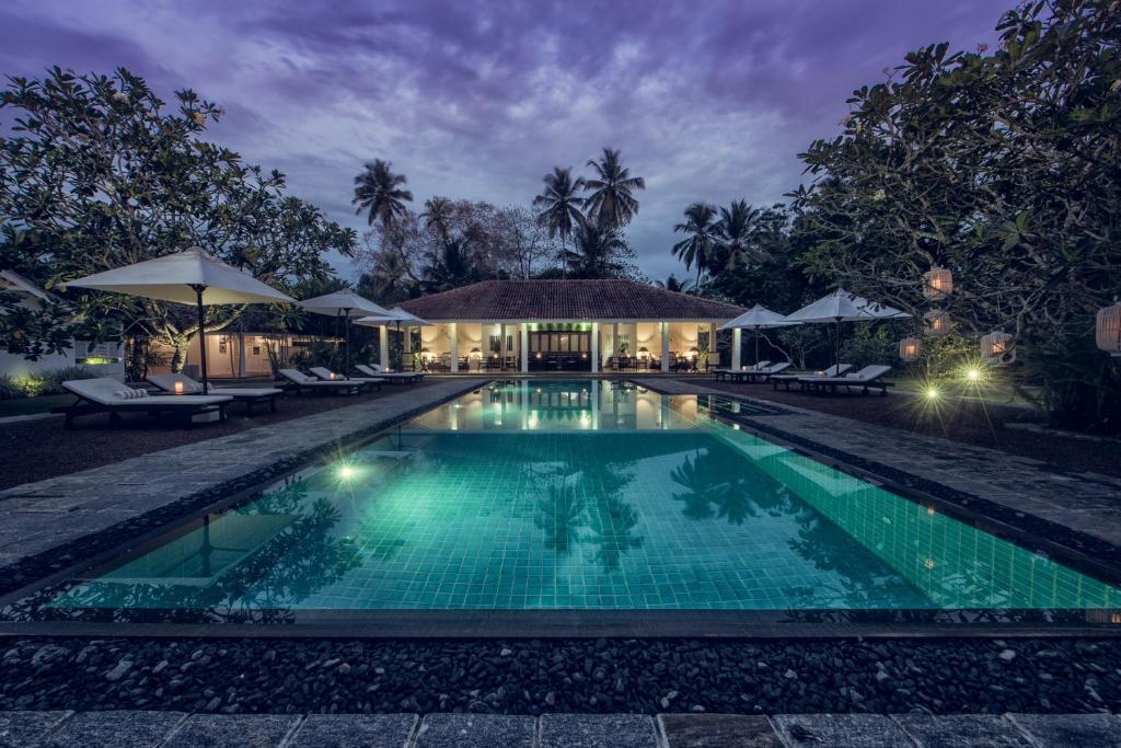 本托塔Nyne Hotels - Rock Villa, Bentota的夜间别墅前的游泳池