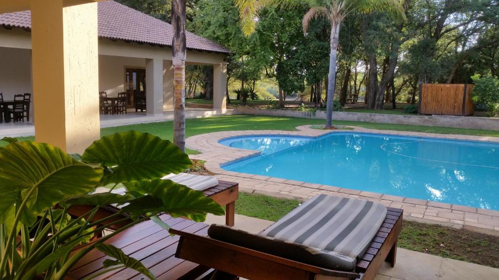 贝拉贝拉萨默西特普雷斯乡村民宿的一个带躺椅和房子的游泳池