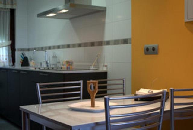 拉斯特雷斯Apartamentos Tajamar的厨房配有桌椅和勺子