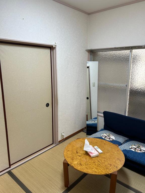 东京ハイツドリーム梦想小屋的一间配有沙发、桌子和门的房间