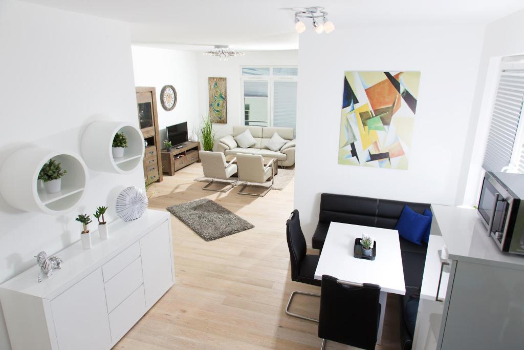 奥斯赛拜-塞林Ferienwohnung Wilma的一间带白色家具的客厅和一间餐厅
