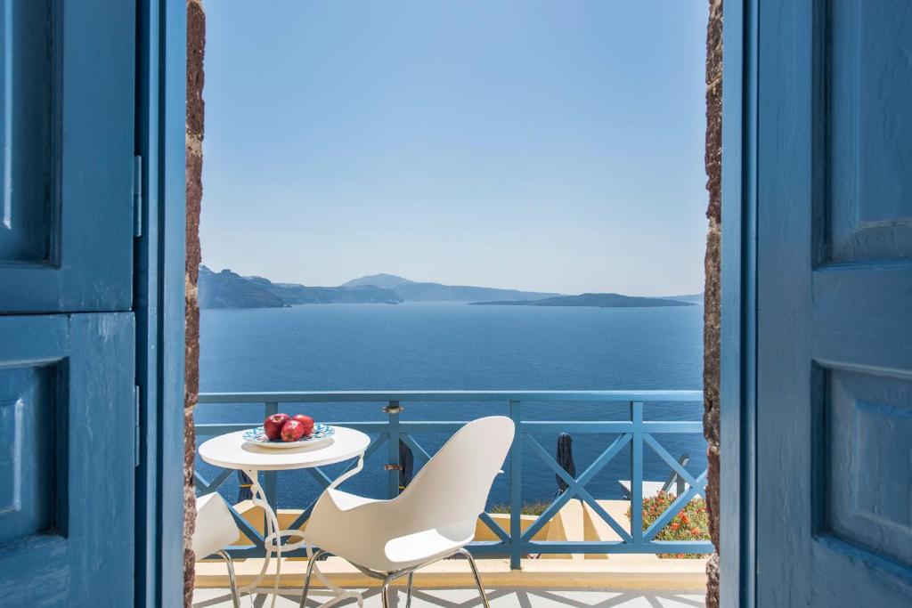 伊亚Horizon Aeifos Suites的阳台配有桌椅,享有水景