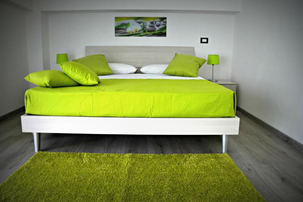贾迪尼-纳克索斯Naxos Apartments的卧室配有一张带绿床单和枕头的大床。